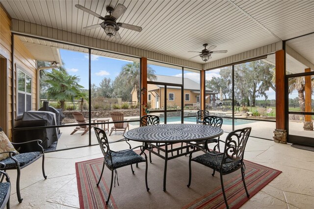 sunroom with a wealth of natural light, floor to ceiling windows, and ceiling fan