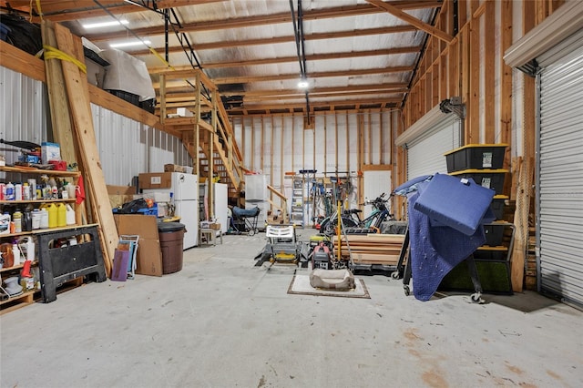 garage with metal wall and freestanding refrigerator