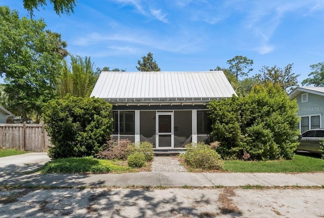 620 NE 6th Ave, Gainesville, FL 32601 - view of front facade with a sunroom, fence, a standing seam roof, and metal roof