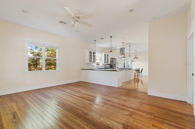 620 NE 6th Ave, Gainesville, FL 32601 - unfurnished living room with light wood-type flooring, baseboards, ceiling fan, and visible vents