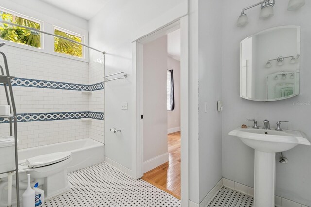 620 NE 6th Ave, Gainesville, FL 32601 - full bath featuring toilet, baseboards, tub / shower combination, and a sink