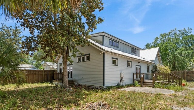 620 NE 6th Ave, Gainesville, FL 32601 - back of house featuring fence, a patio, metal roof, and a deck