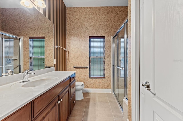 bathroom featuring vanity, tile patterned floors, baseboards, wallpapered walls, and a shower stall