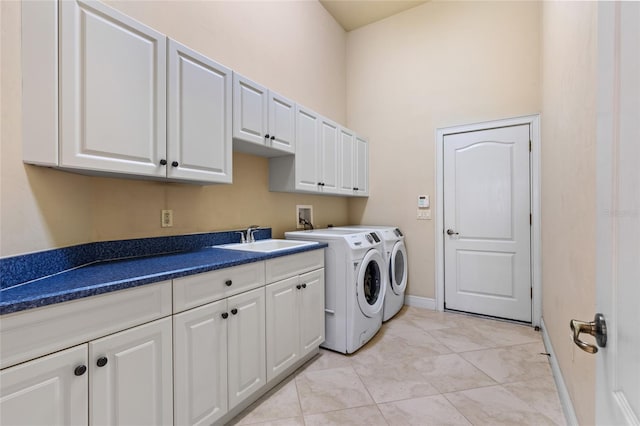 laundry area with cabinet space, a sink, separate washer and dryer, baseboards, and a towering ceiling