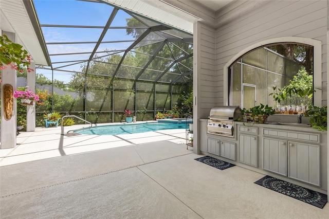 view of swimming pool featuring a patio, glass enclosure, exterior kitchen, and area for grilling
