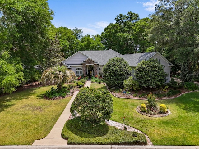 view of front of house featuring a front lawn and roof with shingles