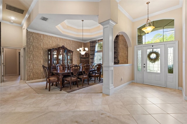 entryway featuring a notable chandelier, visible vents, plenty of natural light, and ornamental molding