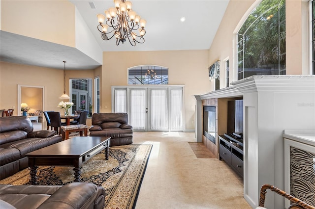living room with an inviting chandelier, high vaulted ceiling, a healthy amount of sunlight, and light colored carpet