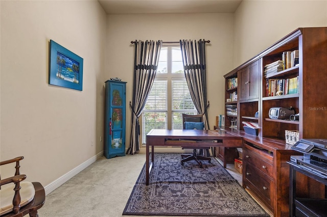 home office featuring baseboards and light carpet