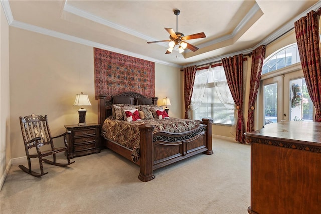 bedroom featuring crown molding, a raised ceiling, baseboards, and light colored carpet