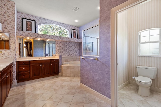 full bath with tile patterned floors, plenty of natural light, a garden tub, and vanity