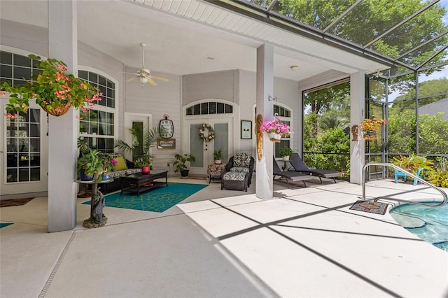 view of patio with glass enclosure, ceiling fan, outdoor lounge area, and an outdoor pool