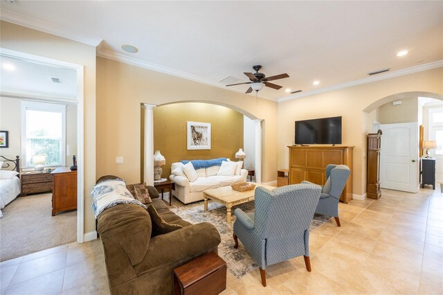 living area with visible vents, a ceiling fan, light tile patterned floors, arched walkways, and crown molding