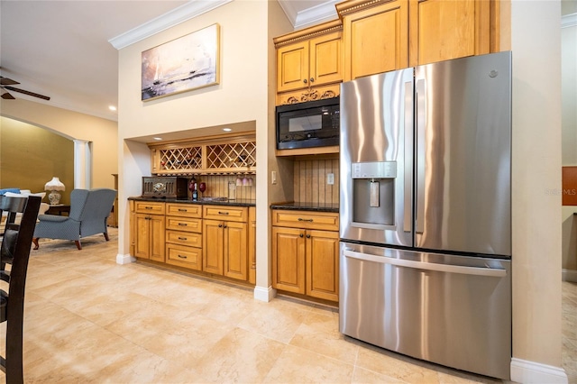 kitchen with arched walkways, crown molding, black microwave, and stainless steel refrigerator with ice dispenser
