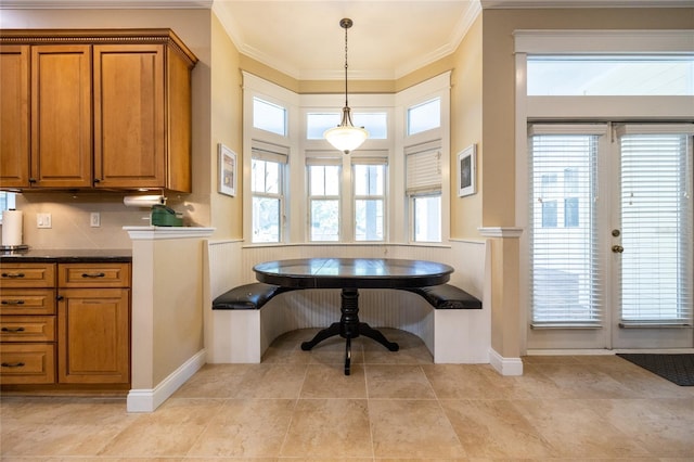 dining room featuring breakfast area, ornamental molding, a wainscoted wall, and light tile patterned floors