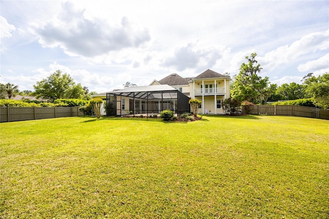 view of yard featuring a fenced backyard and glass enclosure