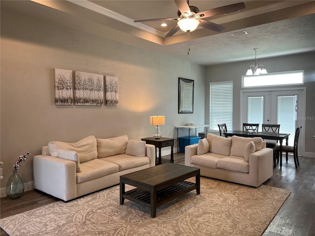living room featuring baseboards, ornamental molding, ceiling fan with notable chandelier, and wood finished floors