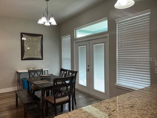 dining area featuring baseboards, french doors, dark wood-style floors, and a notable chandelier