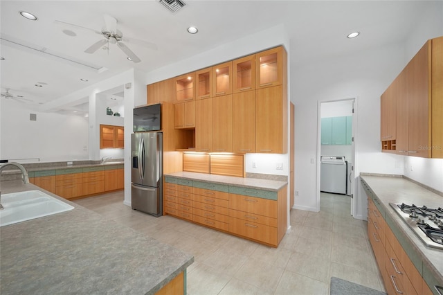 3200 NW 21st Ave, Gainesville, FL 32605 - kitchen featuring stainless steel appliances, a sink, washer / dryer, a ceiling fan, and glass insert cabinets
