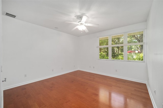 3200 NW 21st Ave, Gainesville, FL 32605 - unfurnished room with wood finished floors, a ceiling fan, and baseboards