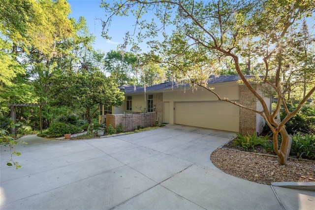 3200 NW 21st Ave, Gainesville, FL 32605 - view of front of home with an attached garage, concrete driveway, brick siding, and stucco siding