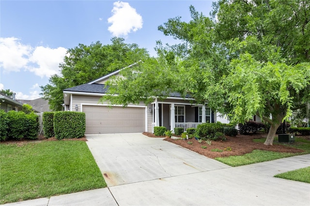 view of property hidden behind natural elements with a garage, a porch, driveway, and a front yard