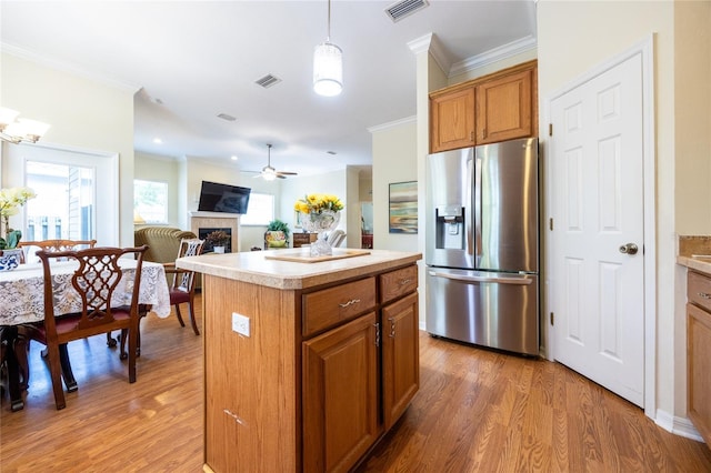 kitchen featuring visible vents, ornamental molding, and stainless steel fridge with ice dispenser