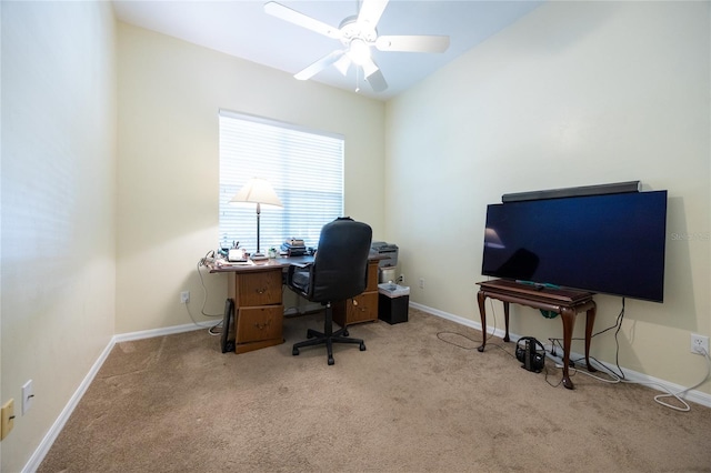 carpeted office space featuring baseboards and a ceiling fan
