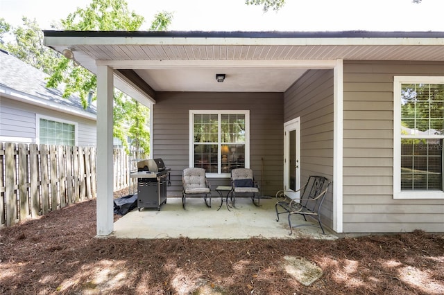 view of patio featuring a grill and fence