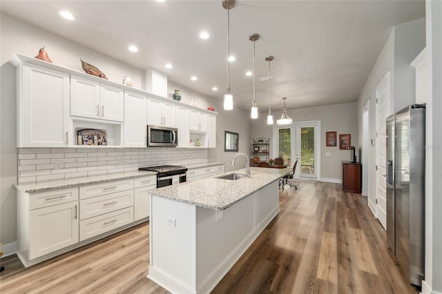 1272 NW 132nd Blvd, Newberry, FL 32669 - kitchen featuring stainless steel appliances, open shelves, a sink, white cabinets, and tasteful backsplash