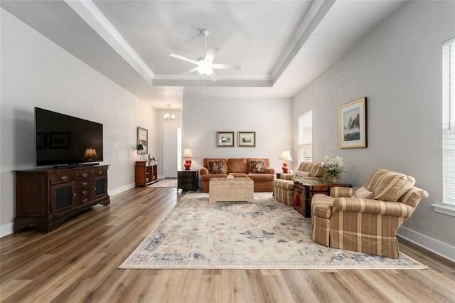 1272 NW 132nd Blvd, Newberry, FL 32669 - living room featuring a raised ceiling, wood finished floors, a ceiling fan, and baseboards