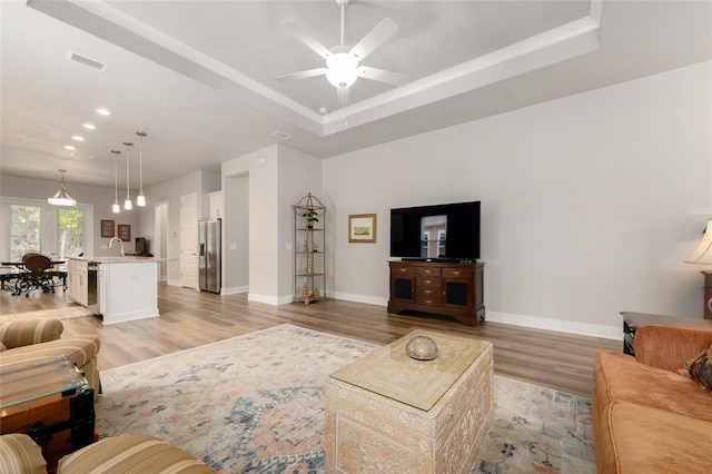 1272 NW 132nd Blvd, Newberry, FL 32669 - living room featuring baseboards, light wood-style flooring, a tray ceiling, recessed lighting, and a ceiling fan