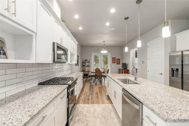 1272 NW 132nd Blvd, Newberry, FL 32669 - kitchen featuring appliances with stainless steel finishes, a sink, a center island with sink, white cabinets, and backsplash