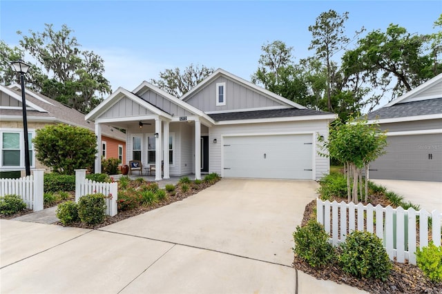 1272 NW 132nd Blvd, Newberry, FL 32669 - view of front of house with board and batten siding, a porch, fence, concrete driveway, and an attached garage