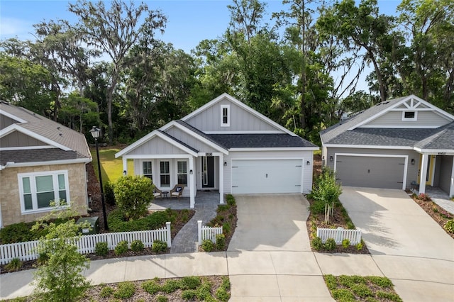 1272 NW 132nd Blvd, Newberry, FL 32669 - view of front facade featuring board and batten siding, driveway, an attached garage, and roof with shingles