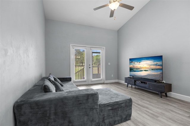 living area featuring high vaulted ceiling, light wood finished floors, baseboards, ceiling fan, and french doors