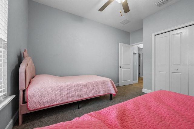 bedroom with baseboards, carpet floors, visible vents, a ceiling fan, and a closet