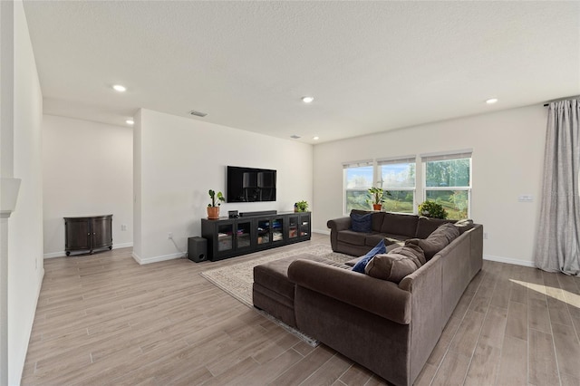 1487 NW 136th Blvd, Newberry, FL 32669 - living room featuring baseboards, light wood-style floors, recessed lighting, and a textured ceiling