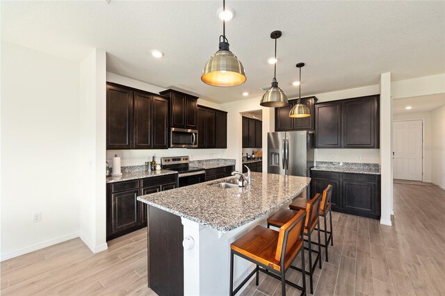1487 NW 136th Blvd, Newberry, FL 32669 - kitchen with a sink, a breakfast bar area, appliances with stainless steel finishes, wood finish floors, and dark brown cabinets