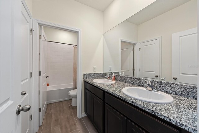 1487 NW 136th Blvd, Newberry, FL 32669 - bathroom featuring double vanity, a sink, wood finish floors, and toilet