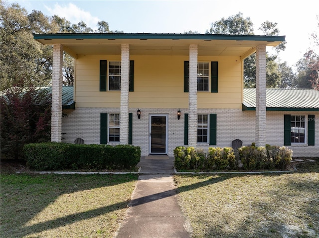 view of front facade featuring a front yard and brick siding