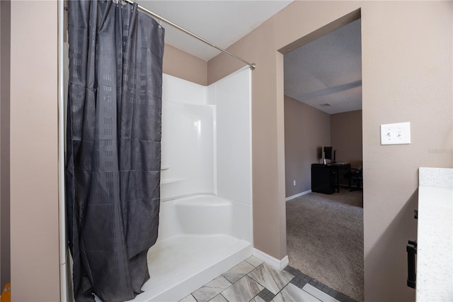 full bath featuring a textured ceiling, a shower with curtain, and baseboards
