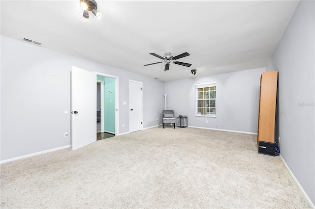 carpeted empty room featuring visible vents, ceiling fan, and baseboards