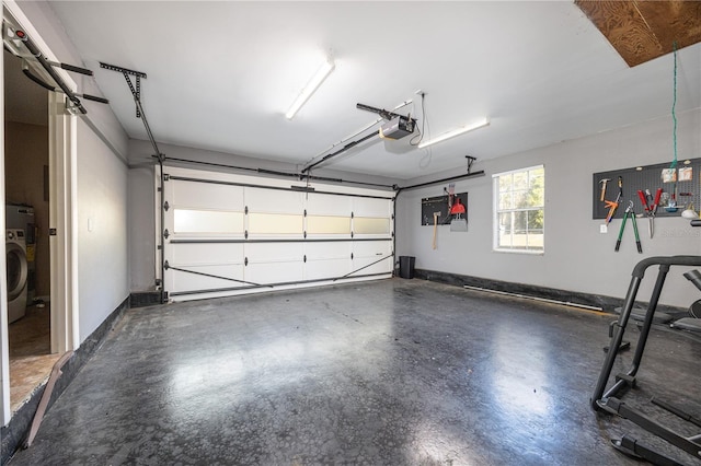 garage with washer / clothes dryer, a garage door opener, and baseboards