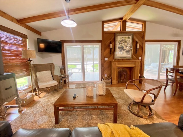 living area with a wealth of natural light, lofted ceiling with beams, and a fireplace