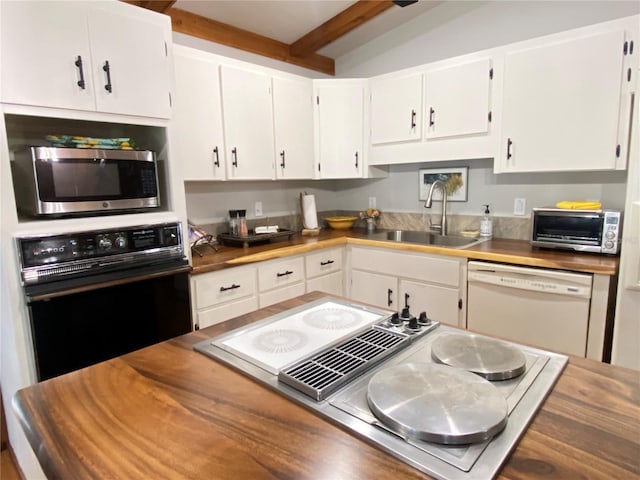 kitchen featuring stovetop with downdraft, stainless steel microwave, a sink, black oven, and white dishwasher