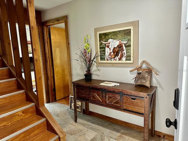 interior space with baseboards and stairway
