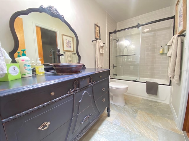 bathroom with toilet, bath / shower combo with glass door, and vanity
