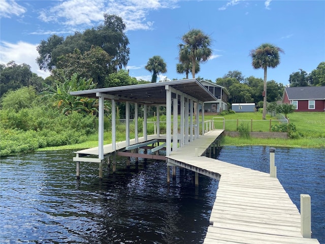view of dock with a water view and a yard