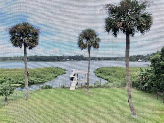 dock area with a water view and a yard
